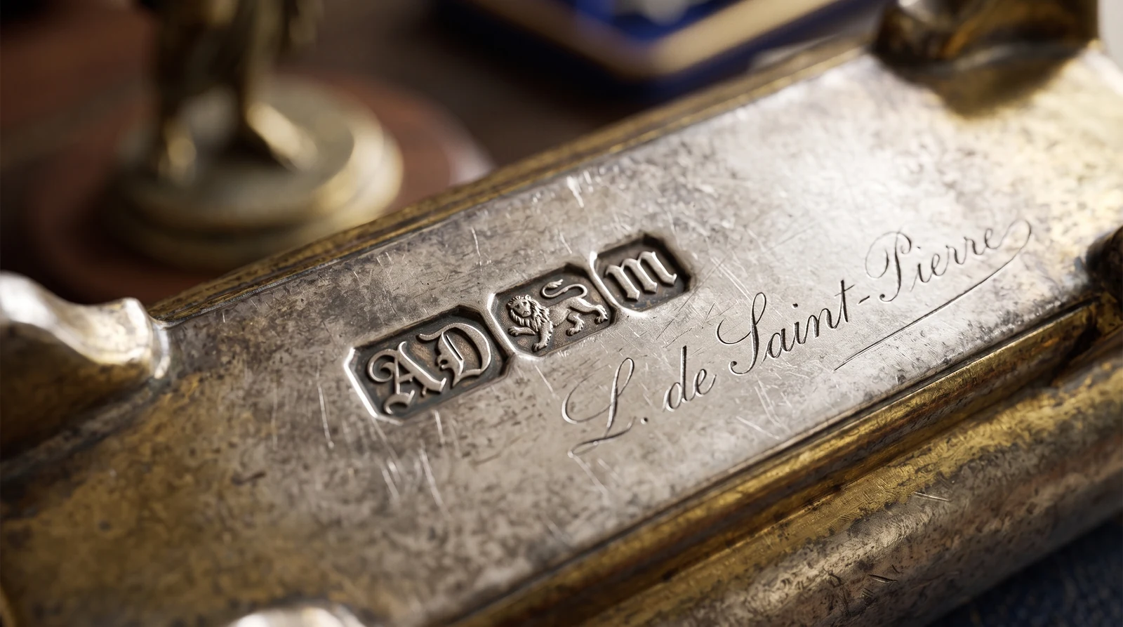 Gros plan sur un poinçon et une signature gravée au dos d'un objet ancien